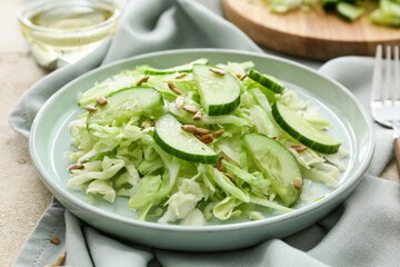 Plate with tasty cabbage salad on light table