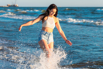 Young woman playing in the sea.woman make in sea water splash.Cheerful young woman having fun on the summer beach.