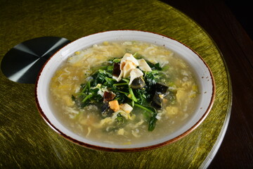 asian premium banquet menu stir fried water spinach vegetables with 3 type of golden eggs in thick gravy sauce on gold background dining table