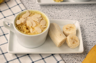 cupcake in a mug with banana pieces. Banana cupcake on a light background. The concept of a dessert in the microwave. bananas cake. High quality photo