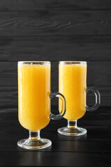 Glasses of tasty pineapple smoothie on dark wooden background