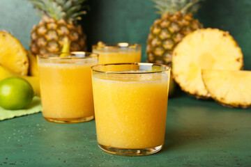 Glasses of tasty pineapple smoothie on color background, closeup