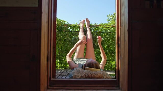 a woman lies on the balcony, listens to music and dances. the joy of living in a new normality after a pandemic