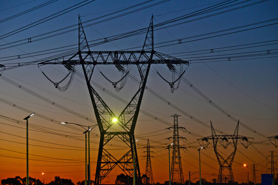 Silhouettes Of Transmission Towers At Sunset.