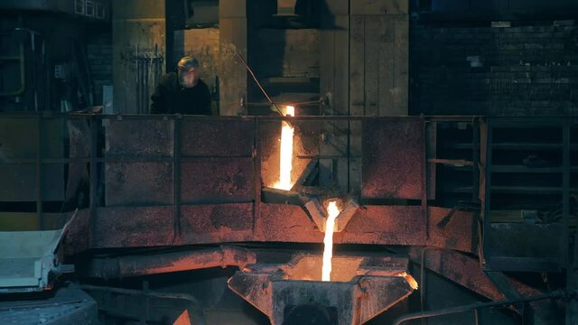 Foundry with a factory worker controlling smelting
