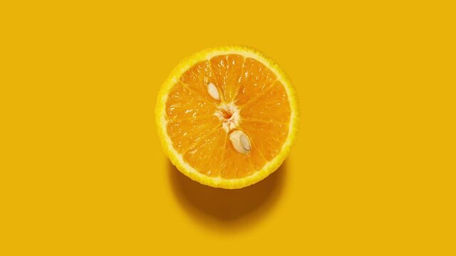 Creative concept stop motion video footage movie gif. Food health diet cut raw orange fruit on orange background.