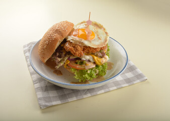chef handmade giant deep fried crispy chicken with fried egg and vegetables cheesy burger in japanese sesame sauce western fast food halal menu