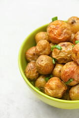 Bowl with tasty baked potato on light background