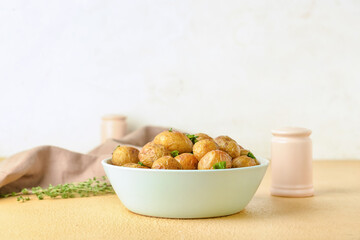 Bowl with tasty baked potato on table