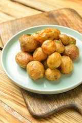 Plate with tasty baked potato on wooden background