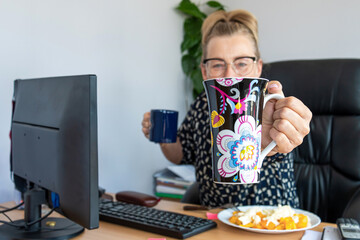 attractive middle-aged woman with glasses at noon in the office at the desk