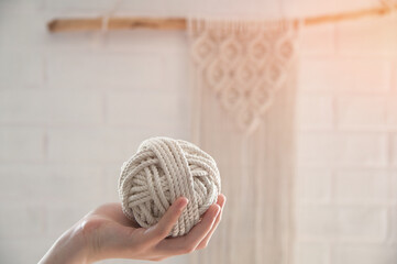 ball of yarn for knitting macrame lies on the hand