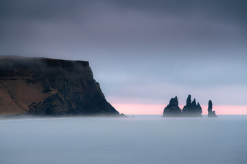 Scenic Reynisdrangar cliff during sunrise on a stormy cloudy morning in Iceland