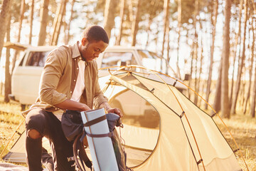 Man is traveling alone in the forest at daytime at summer