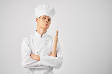 a man in a chef's form of a bell in the hands of a professional work light background