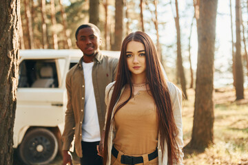 Positive emotions. Young couple is traveling in the forest at daytime together