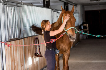 Owner thanks her horse for wonderful ride. Woman is stroking horse , they are both in great mood....