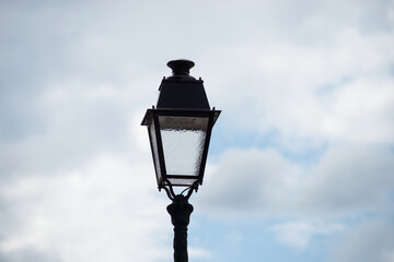 Fototapeta na wymiar Closeup of vintage street light in the street on cloudy sky background