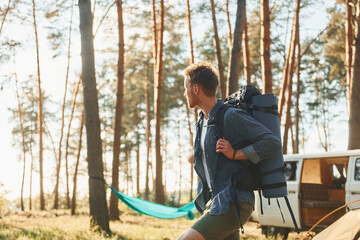 Looks at location. Man is traveling alone in the forest at daytime at summer