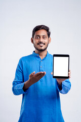 Young indian man showing tablet over white background.