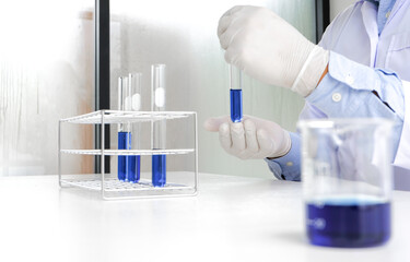 Science innovative Male medical or scientific laboratory researcher performs tests with blue liquid in laboratory. equipment science experiments technology Coronavirus Covid-19 vaccine research