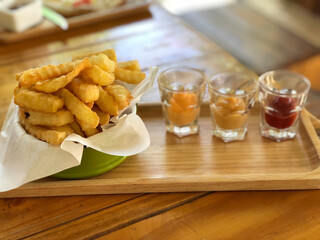 French fries in a bowl on a wooden background