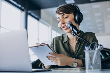 Young woman with microphone recording voice acting