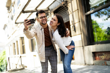 Happy young couple outdoors. Loving couple taking selfie photo.