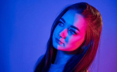 Portrait of fashionable young woman that standing in the studio with neon light