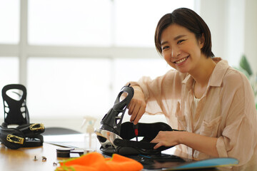 スノーボード板の手入れをする女性