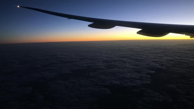 Silhouette of an airplane wing in sunset sunrise time during flight.	
