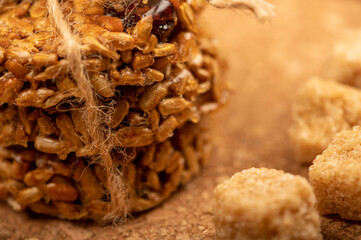 Homemade cookies with sunflower seeds and raisins tied with string and pieces of brown cane sugar on a wooden table. Close-up Selective focus.