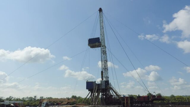 Top Drive System (TDS) Spinning for Oil Drilling Rig at blue sky - Oil and Gas Industry.