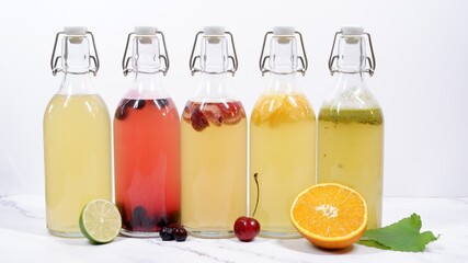 5 flavored Kombucha swing top bottles in front of light background
