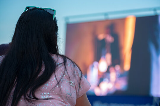 Summer open-air cinema. Woman watching a movie