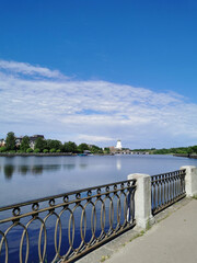 The embankment of the Salakka - Lahti Bay, in the distance the St. Olaf Tower in the Vyborg Castle in the city of Vyborg against the blue sky.