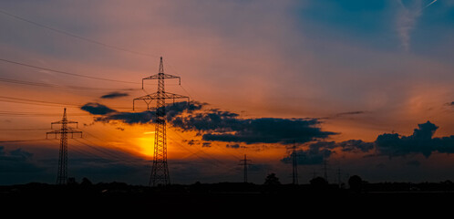 Beautiful sunset with dramatic clouds and powerlines near Tabertshausen, Bavaria, Germany