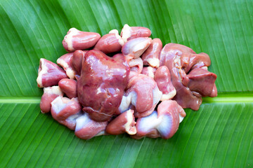 Mixed chicken entrails on banana leaf background.