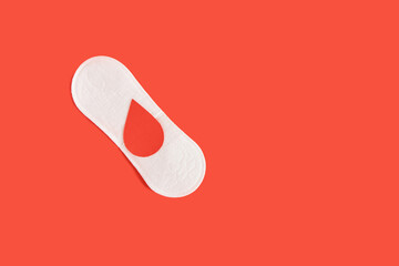 sanitary pad and a drop of blood from paper on a red background
