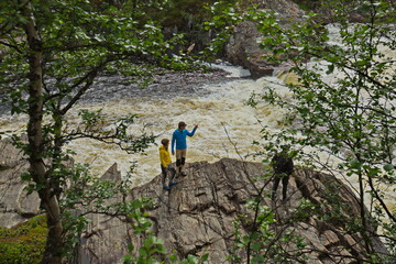 Tourists at the waterfall on the banks of the Titovka River.