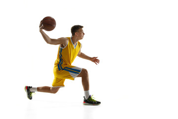 Fototapeta na wymiar Side view. One young man, basketball player with a ball training isolated on white studio background. Advertising concept. Caucasian athlete in action.