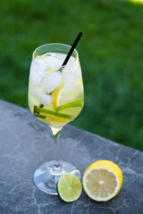High-stemmed glass with lemon and lime lemonade. An exquisite summer refreshing drink. 