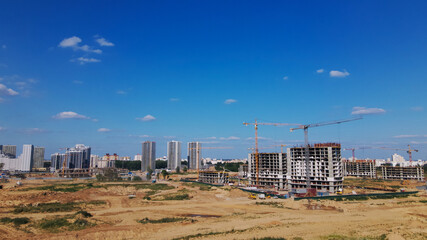 Modern urban development. Construction site with multi-storey buildings under construction. Construction of a new city block. Aerial photography.