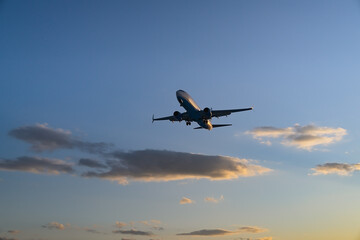 The plane comes in for landing at sunset