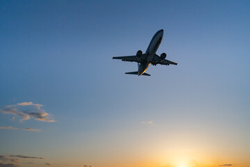 Fototapeta na wymiar The plane comes in for landing at sunset