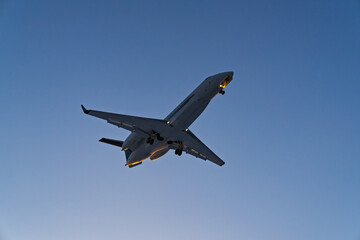 The plane comes in for landing at sunset