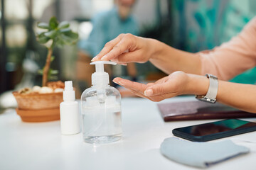 Close-up of woman using hand sanitizer while being at restaurant.