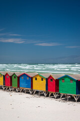 Fototapeta premium Famous colorful beach houses in Muizenberg near Cape Town, South Africa with Hottentots Holland mountains in the background.