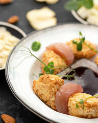 Exotic food. Appetizer in almond petals, garnished with microgreens of peas. Soft focus. Close-up shot. Vertical format.