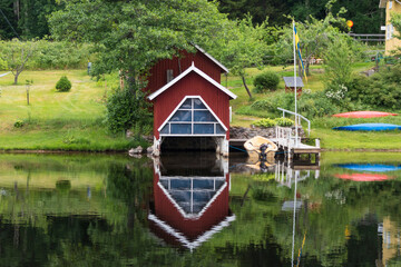 Fototapeta premium Haverud, Sweden A house is reflected in the water along the Dalsland Canal in western central Sweden on a bridge.